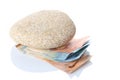 Financial debt concept: heavy stone push down some banknotes isolated on white background with copy space for your text