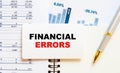 FINANCIAL ERRORS - business text on a business card against a background of charts Royalty Free Stock Photo