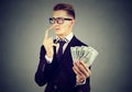 Financial fraud concept. Liar business man in suit and glasses with dollar cash Royalty Free Stock Photo