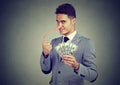 Financial fraud concept. Sly liar young business man with dollar cash Royalty Free Stock Photo