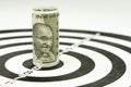 Financial goal or target concept, Indian rupee banknote roll targeted at the center of yellow dartboard