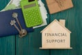 financial helping concept - little house with text Financial support, keys, calculator, passport, money Royalty Free Stock Photo