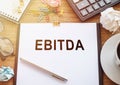 Financial Planning Document Featuring EBITDA on Desk in Daylight