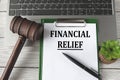 FINANCIAL RELIEF - words on a white sheet on the background of a laptop, a court hammer and a pen