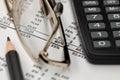 Financial report, glasses, calculator and pencil on the table in the office. A paper sheet full of business data. Accounts number Royalty Free Stock Photo