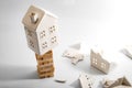 Financial risk, unstable real estate investment and shaky housing market concept with a home on stacked wooden building blocks