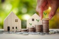 Hand putting stack coins for growing with sunlight bokeh background and tree growing on coin Royalty Free Stock Photo