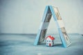 Financial savings concept with little toy house and bundles of us dollars in the form of a roof, as a symbol of protection against Royalty Free Stock Photo