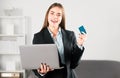 Financial services, credit card banking concept. Portrait of young businesswoman holding laptop computer and credit card Royalty Free Stock Photo