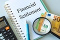 Financial settlement written by an accountant in a business notebook, Calculator, magnifying glass and a bundle of euro banknotes Royalty Free Stock Photo