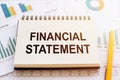 Financial Statemen - written on notepad on financial charts and graphs with yellow pen Royalty Free Stock Photo