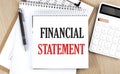 FINANCIAL STATEMENT is written in white notepad near a calculator, clipboard and pen. Business concept Royalty Free Stock Photo