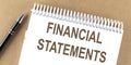 FINANCIAL STATEMENTS text on a notepad with pen, business Royalty Free Stock Photo