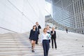 Financial team going down stairs in with tablet, case and talk