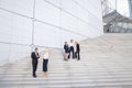 Financial team going down stairs in with tablet, case and talk