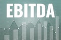 Financial term EBITDA - Earnings before interest, taxes, depreciation and amortization on gray finance background from graphs,