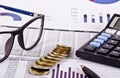 Financial tools, calculator, pen and specs over a report Royalty Free Stock Photo