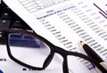 Financial tools, pen pointing over a report and spectacles Royalty Free Stock Photo