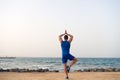 Find balance and unite with nature. Yoga practice helps find harmony and balance. Man practicing yoga sea beach Royalty Free Stock Photo