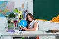 Find the location. cheerful kid learning geography. modern education. knowledge day. child pupil use globe. girl is Royalty Free Stock Photo