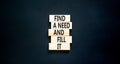 Find a need and fill it symbol. Concept words Find a need and fill it on wooden blocks on a beautiful black table black background