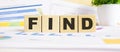 FIND word on wooden cubes. The background is a business graphs. Business and finance concept