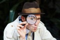 Finding all the clues. Curious private investigator looking through a magnifying glass. Royalty Free Stock Photo