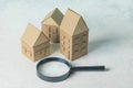 Finding or choosing the best home. Magnifying glass and cardboard miniature houses. Sale or rental of housing