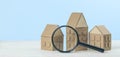 Finding or choosing the best home. Magnifying glass and cardboard miniature houses. Sale or rental of housing