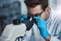 Finding the fault. a young male scientist working in a lab with a microscope. Royalty Free Stock Photo