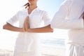 Finding harmony in a tranquil setting. a young man and woman doing yoga beside the sea.