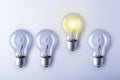 Finding innovative solutions and creative ideas, being unique, thinking different concept. Group of light bulbs with one glowing Royalty Free Stock Photo
