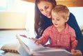 Finding joy in new tales. Shot of a mother reading a book with her little son at home. Royalty Free Stock Photo