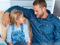 Finding a part of you in another person. an adorable little girl sitting on the sofa sharing headphones with her father. Royalty Free Stock Photo