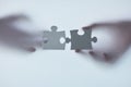 Finding the right fit for your business. Defocussed shot of two unrecognizable businesspeople holding two puzzle pieces Royalty Free Stock Photo