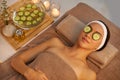 Finding serenity at the spa. A beautiful young woman lying on a massage table at the spa with cucumer over her eyes.