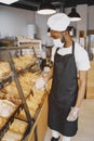 Fine African American man in mask offering pastry