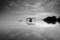 Fine art Black & white image of beautiful landscape of the beach at morning. Fisherman boat and clouds reflecting in the water. Royalty Free Stock Photo