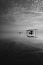 Fine art Black & white image of beautiful landscape of the beach at morning. Fisherman boat and clouds reflecting in the water. Royalty Free Stock Photo