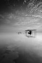 Fine art Black & white image of beautiful landscape of the beach at morning. Fisherman boat and clouds reflecting in the water. Royalty Free Stock Photo