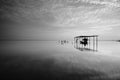 Fine art Black & white image of beautiful landscape of the beach at morning. Fisherman boat and clouds reflecting in the water. Royalty Free Stock Photo