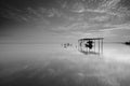 Fine art Black & white image of beautiful landscape of the beach at morning. Fisherman boat and clouds reflecting in the water. Royalty Free Stock Photo