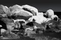 Snowy and icy rocks in the ocean. Black and white