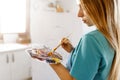 Fine art school. Closeup of artist hands holding wooden palette, mixing acrylic paint with brush.Artist woman with