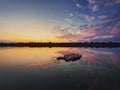 Fine art shot with an old, rusty catamaran frame forgotten on the pond. Scenery landscape, peaceful sunset sky background with