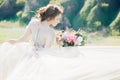 Fine art wedding photography. Beautiful bride with bouquet and dress with train in nature Royalty Free Stock Photo