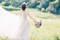 Fine art wedding photography. Beautiful bride with bouquet and dress with train in nature Royalty Free Stock Photo