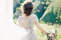 Fine art wedding photography. Beautiful bride with bouquet and dress with train in nature Royalty Free Stock Photo