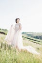 Fine art wedding photography. Beautiful bride with bouquet and dress with train in nature Royalty Free Stock Photo