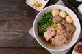Fine cut white rice noodle in pork soup with meatball and pork in white bowl on wooden table Royalty Free Stock Photo